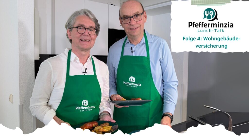 Uwe Schumacher von der Domcura mit Pfefferminzia-Geschäftsführer Matthias Heß in der Küche. Beide halten einen Teller mit Currywurst in der Hand.