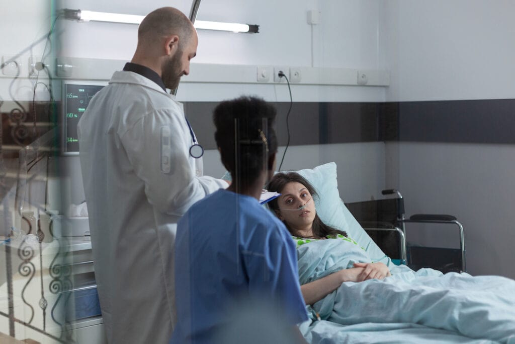 Patientin im Krankenbett sprich mit Arzt und Krankenschwester: Es gibt immer mehr PKV-Premiumtarife.