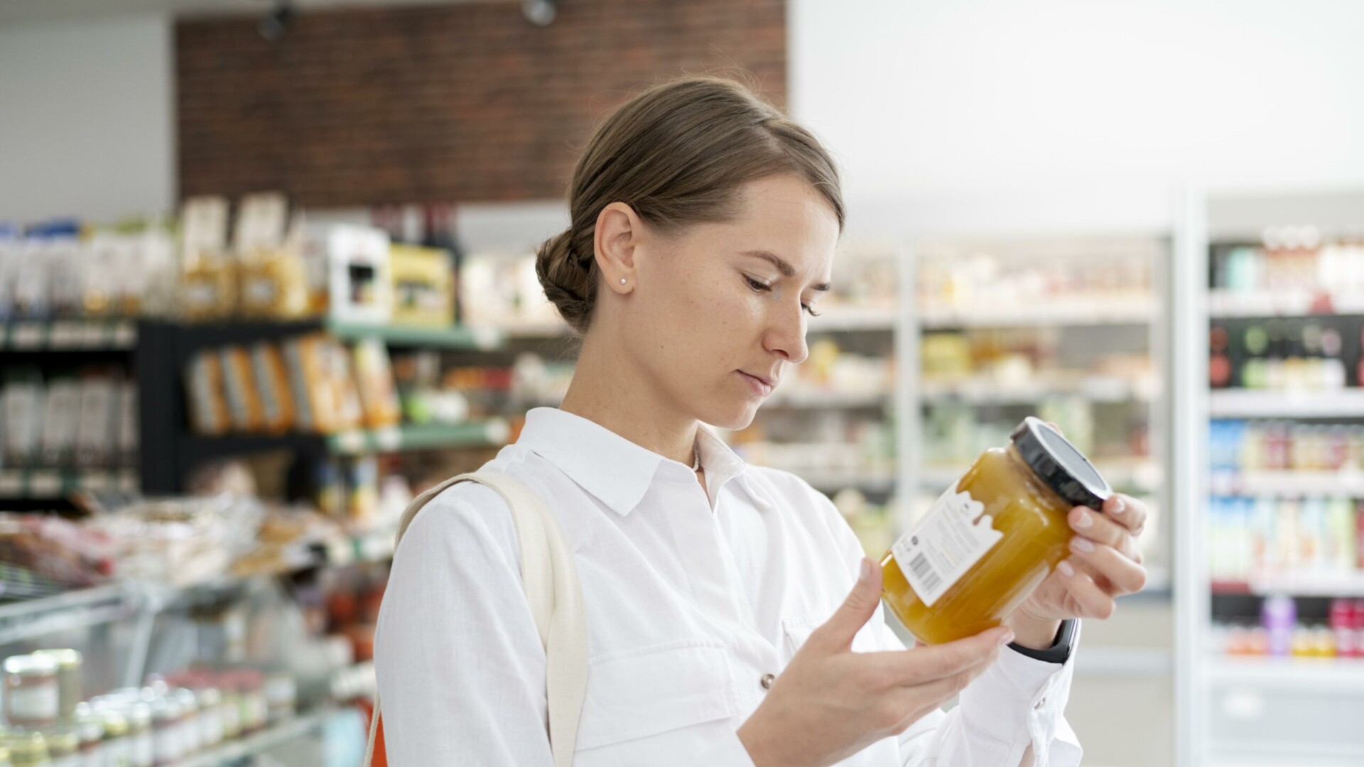 Frau prüft Inhaltsstoffe im Supermarkt: Yougov und das Handelsblatt haben Versicherer mit dem besten Preis-Leistungs-Verhältnis ermittelt.
