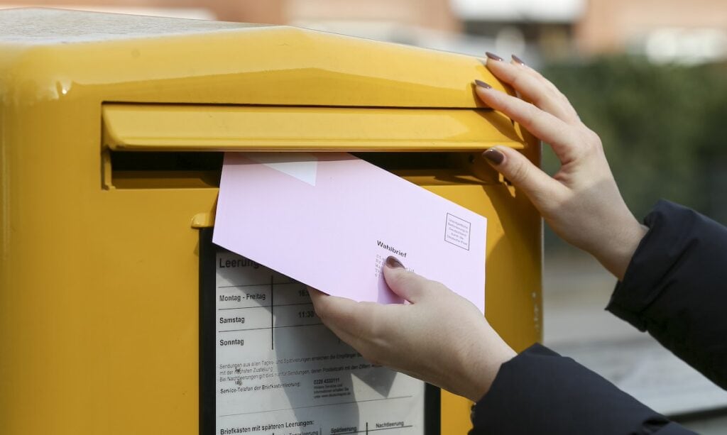 Eine Frau wirft Briefwahlunterlagen zur Bundestagswahl 2025 ein: Von der neuen Bundesregierung erhoffen sich viele eine Reform der privaten Altersvorsorge.