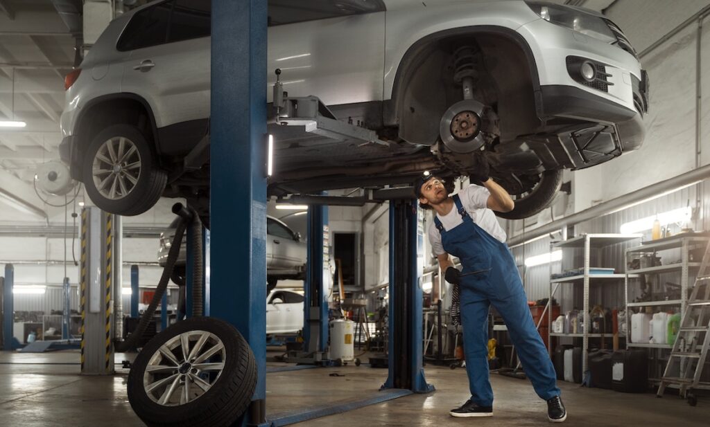 Automechaniker repariert Auto in Hebebühne: Die Huk-Coburg gehört in der Kategorie KFZ zu den Preisträgern des Versicherungs-Awards 2025.