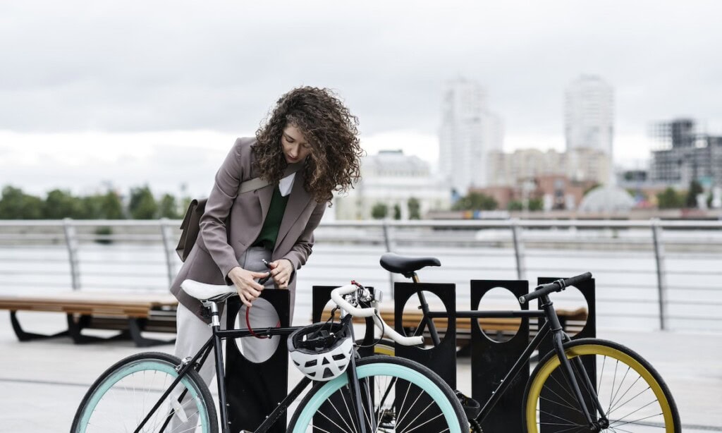 Junge Frau mit Fahrrad: Je teurer das Rad ist, desto eher lohnt sich eine Fahrradversicherung.