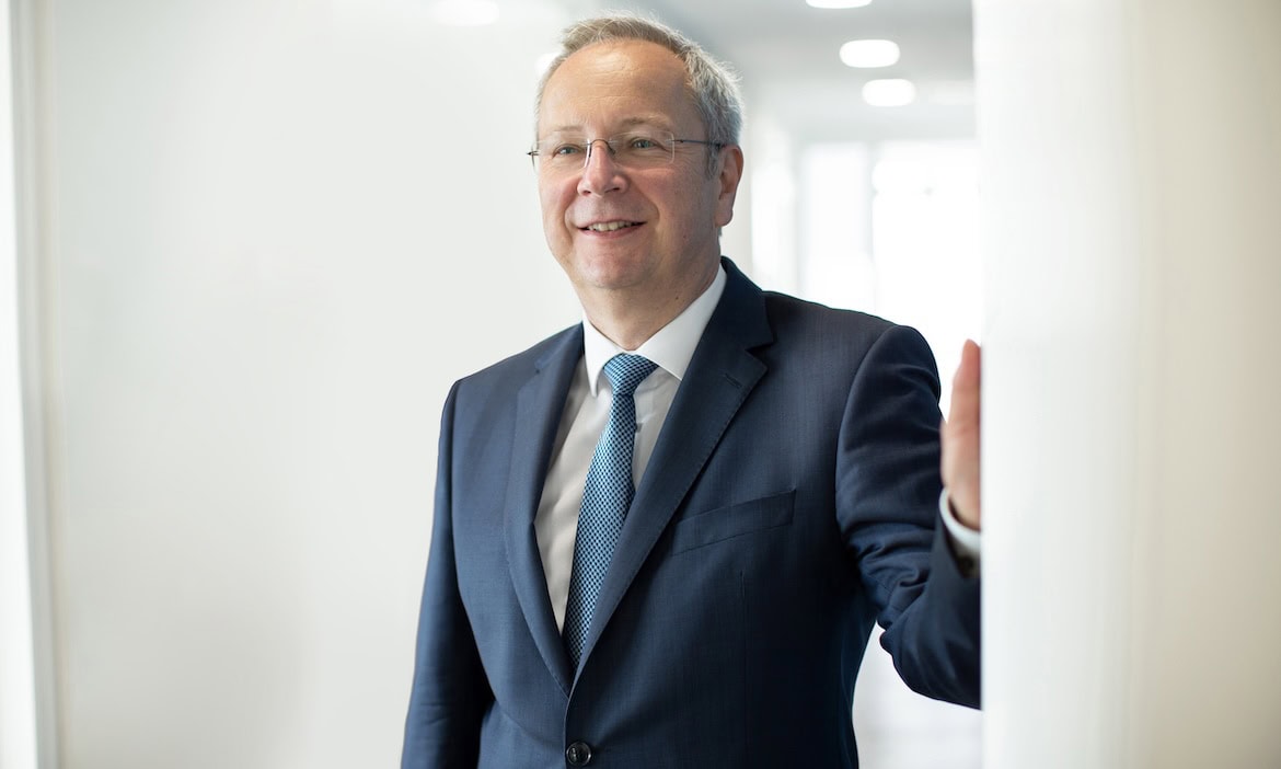 Versicherungsberater in professionellem Anzug, Vertrauen und Kompetenz symbolisieren, maßgeschneiderte Versicherungslösungen.