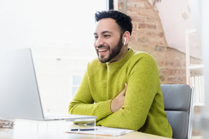 Händler im Homeoffice mit Laptop und Headset, Kundenservice, professionell, flexibles Arbeiten.