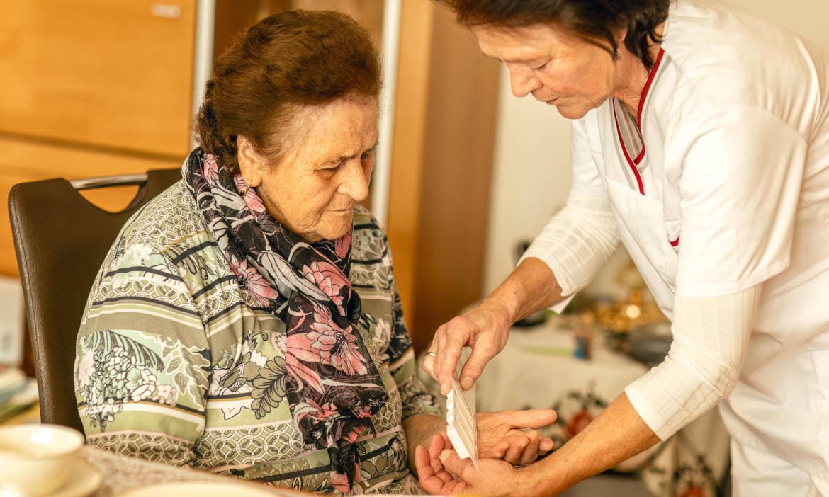 Hautpflege bei älteren Menschen, Pflege im Alter, medizinische Versorgung, Arzt und Seniorin, professionelle Pflegekraft, Betreuung älterer Personen, medizinische Behandlung im Pflegeheim.