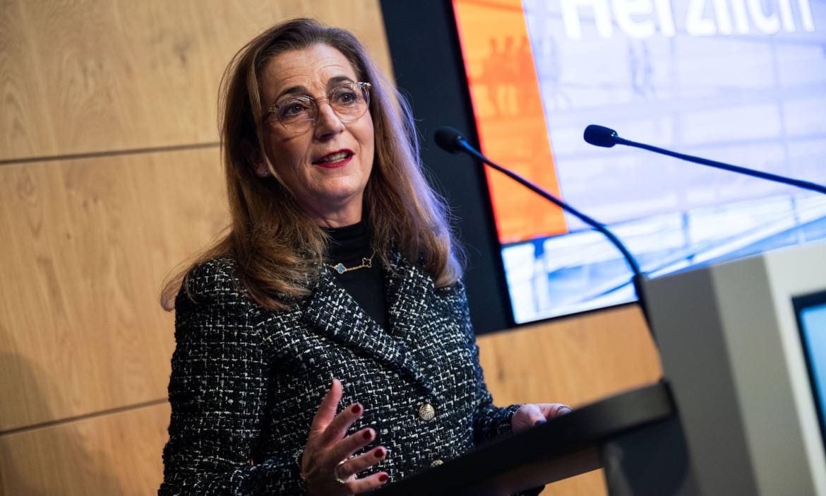 Frau spricht beim CDU-Wirtschaftsrat über Zahnbehandlung und Herausforderungen.