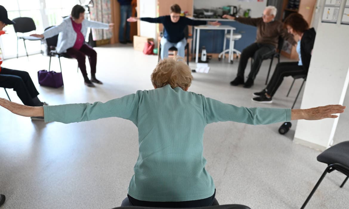 Senioren im Pflegekurs bei Bewegungstherapie, betreut von Pflegekasse.