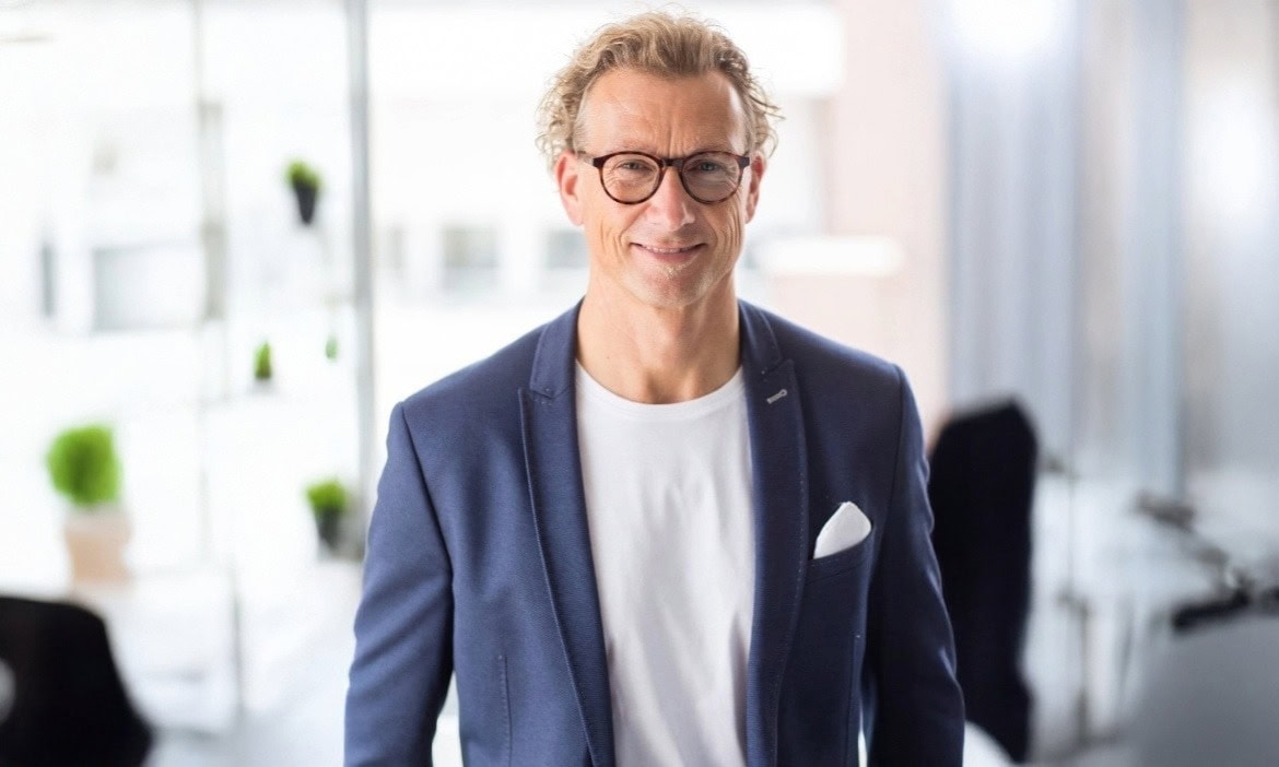 Alter Mann in Businesskleidung vor modernem Büro.