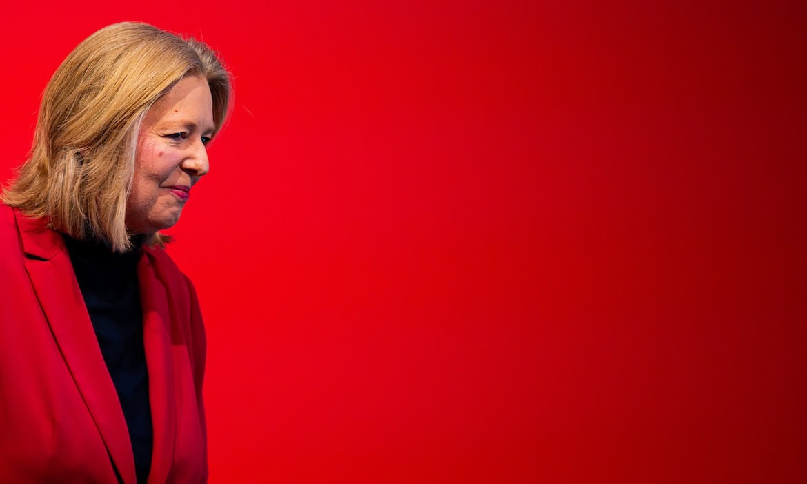 Frau diskutiert das Zweite Betriebsrentenstärkungsgesetz vor rotem Hintergrund.