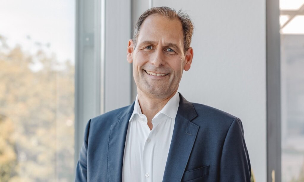 Erfolgreicher Finanzberater in Business-Umgebung, smiling, professionell gekleidet.