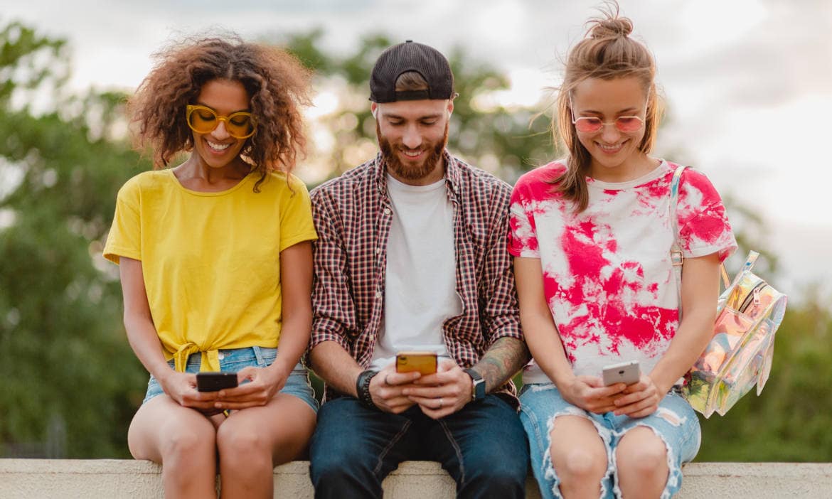 Junge Menschen nutzen KI-basierte Apps zur Versicherungssuche im Freien.