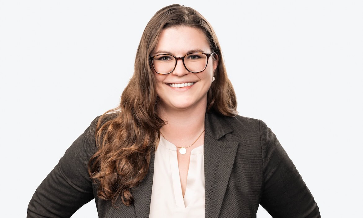 Versicherungsberaterin mit Brille und freundlichem Lächeln, symbolisiert digitale Kundenbindung in d.