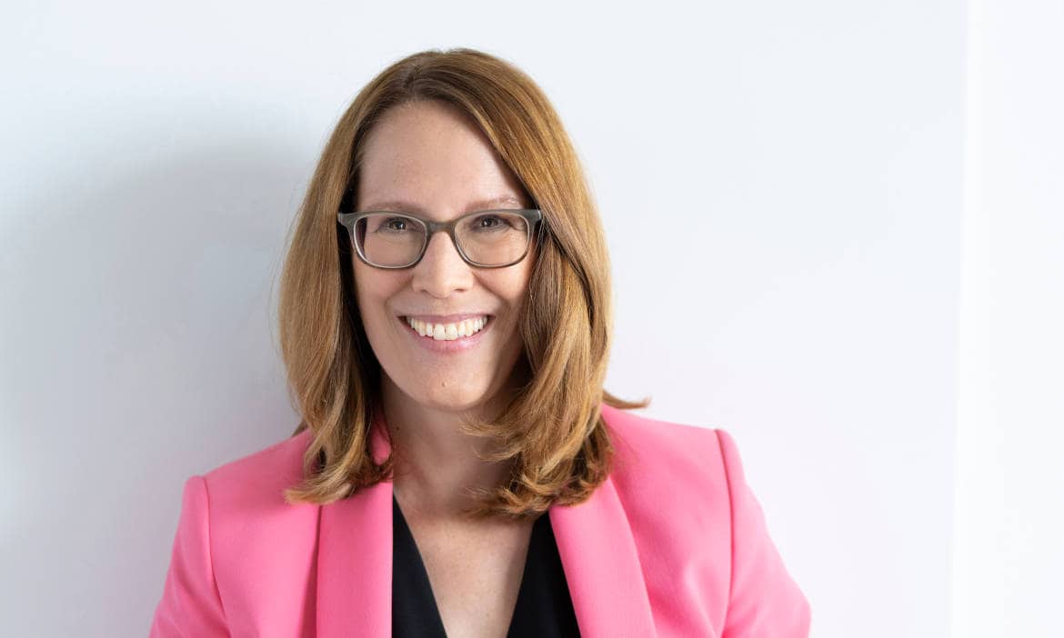 Ex-Interhyp-Vorständin bei Finanztip, lächelnd und professionell in pinkem Blazer.