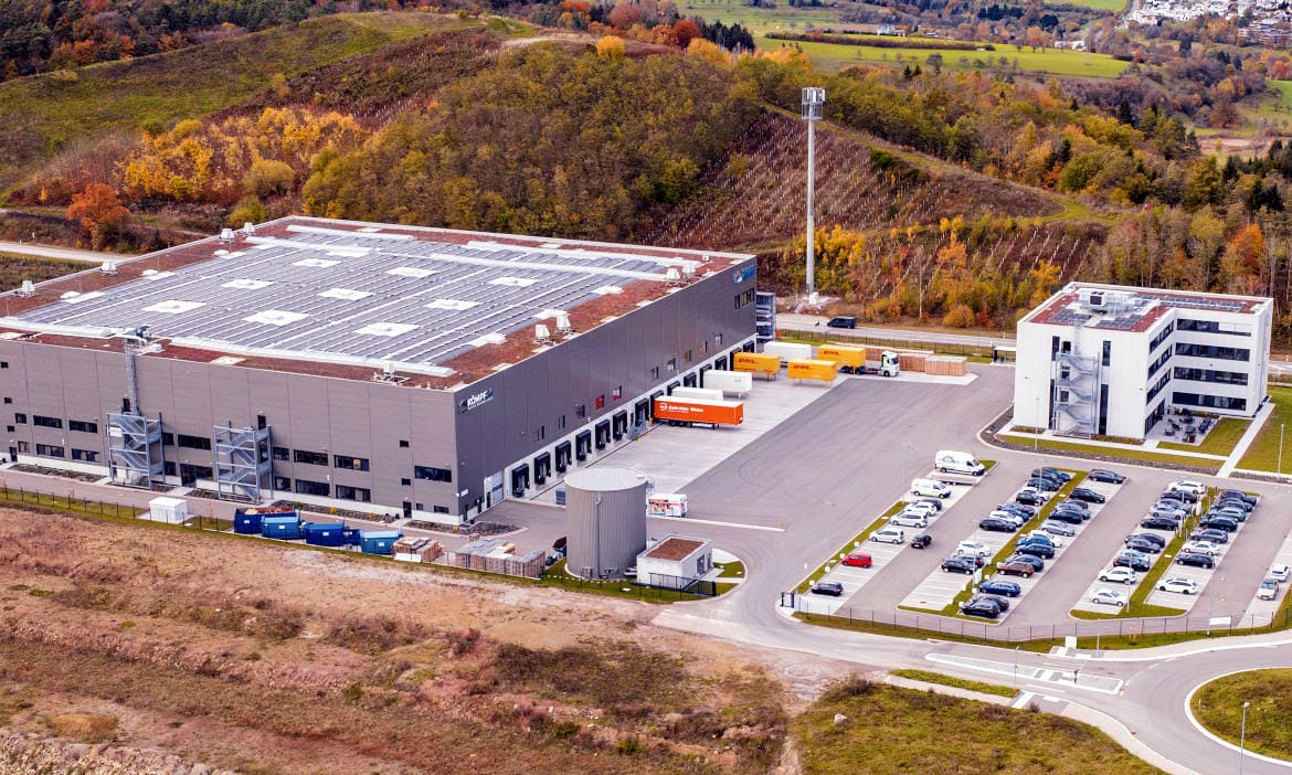 Modernes Lagerhaus mit Sicherheitszäunen und Überwachungssystemen.