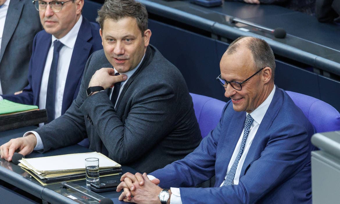 Männer im Parlament diskutieren über Fördererhöhungen und Kostensenkungen.