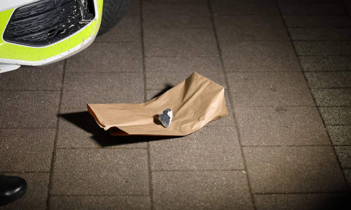 Verkehrsunfall mit Papier und Stein auf Gehweg.