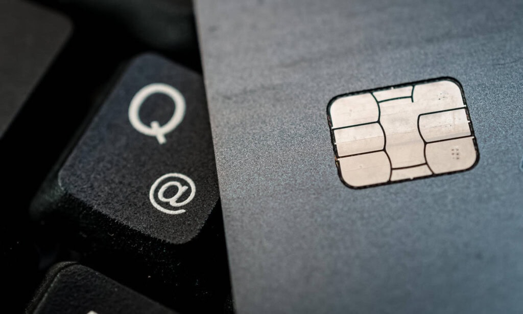 Nahaufnahme einer Kreditkarte und Tastatur mit E-Mail- und Quell-Symbol.