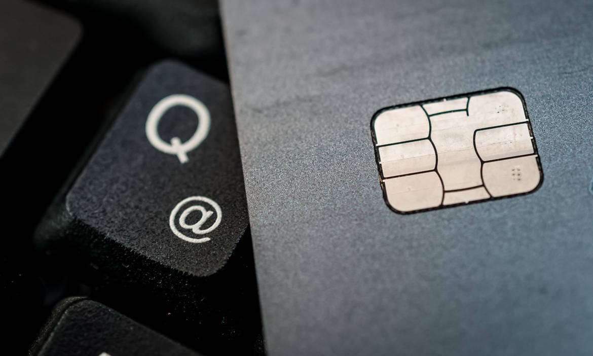 Nahaufnahme einer Kreditkarte und Tastatur mit E-Mail- und Quell-Symbol.