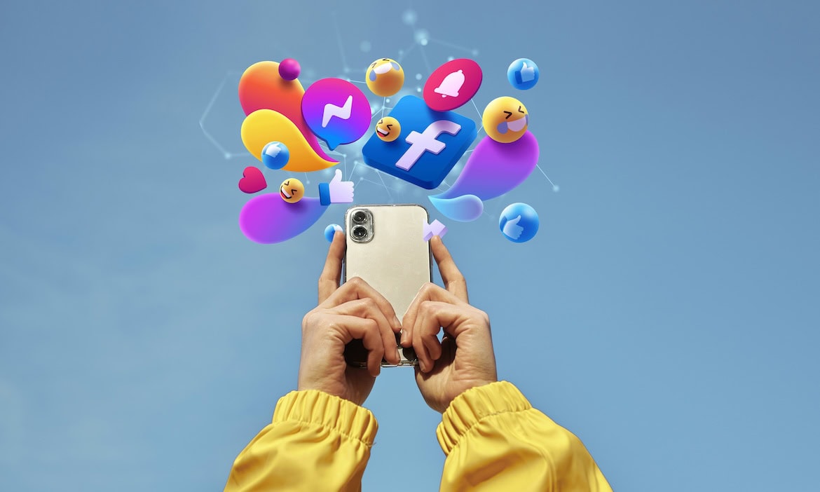 Person hält Smartphone mit Social Media Icons über dem Himmel.