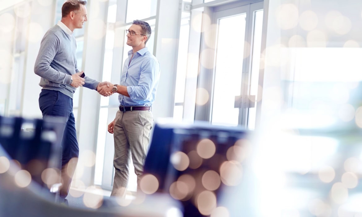 Zwei Männer schütteln sich die Hand bei einer Preisverleihung.