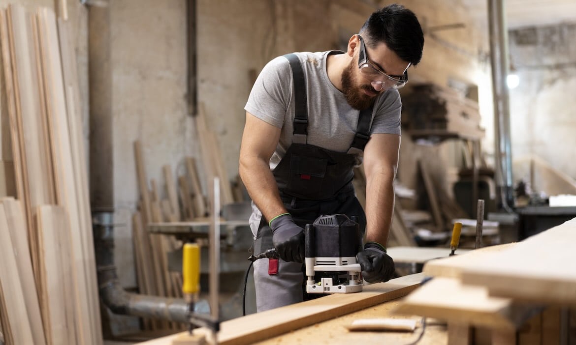 Handwerker arbeitet mit Stichsäge an Holz im Werkstattatelier.