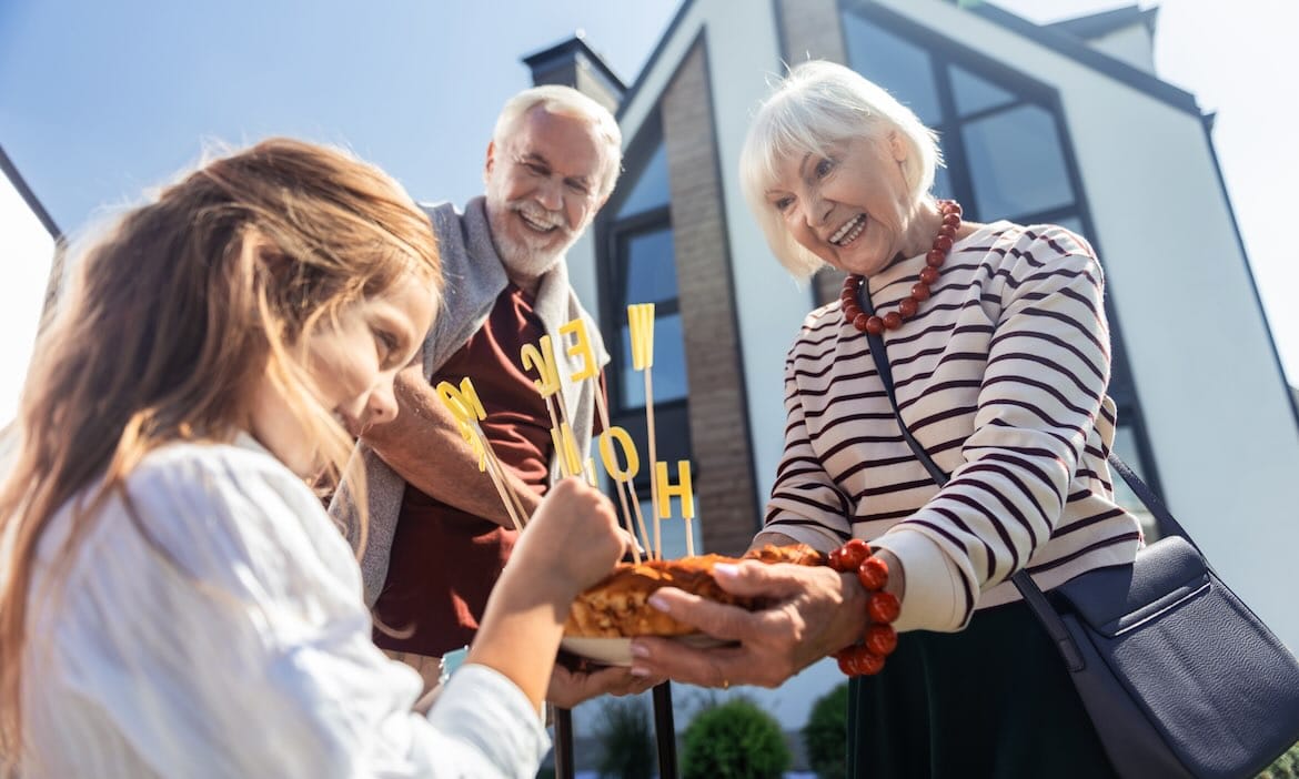 Ältere Frau übergibt Haus an Enkel, Familie freut sich auf Immobilienerbe.