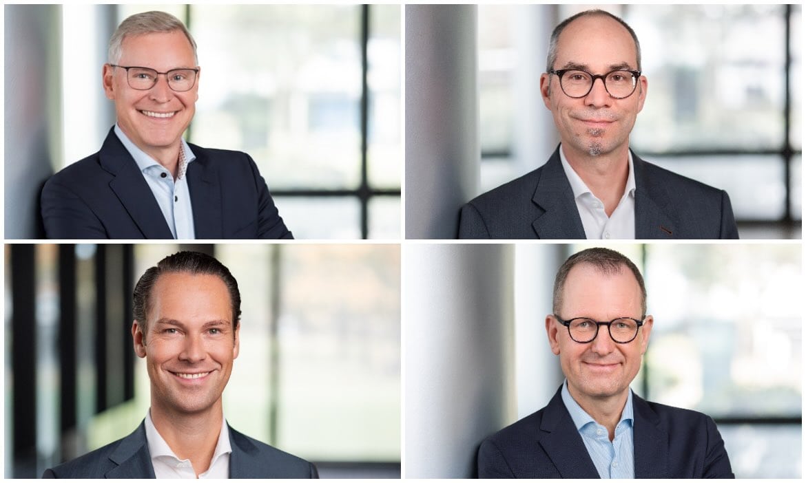 Vier Männer in Businesskleidung sprechen über Altersvorsorge und Reformen.