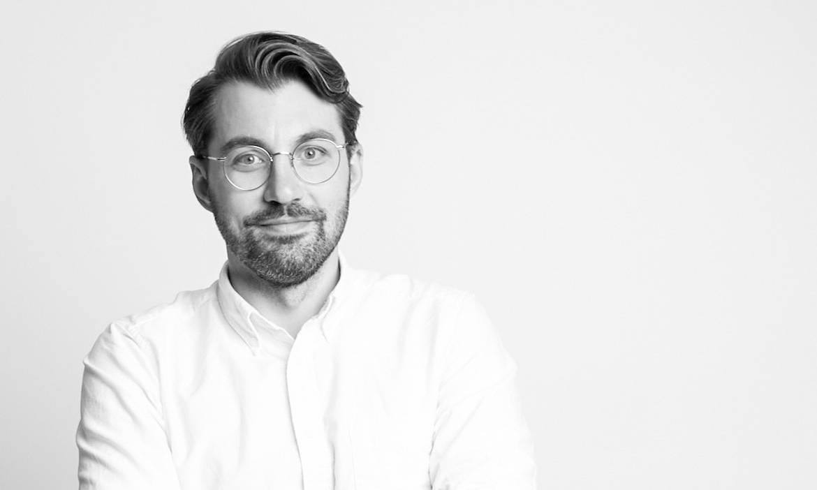 Mann mit Brille und Hemd, professionell, im weißen Hintergrund.