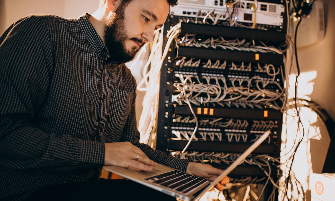 IT-Experte arbeitet an Servern und Netzwerktechnik in einem Rechenzentrum.