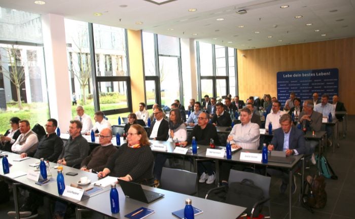 Teilnehmer bei Business-Konferenz in moderner, heller Halle.