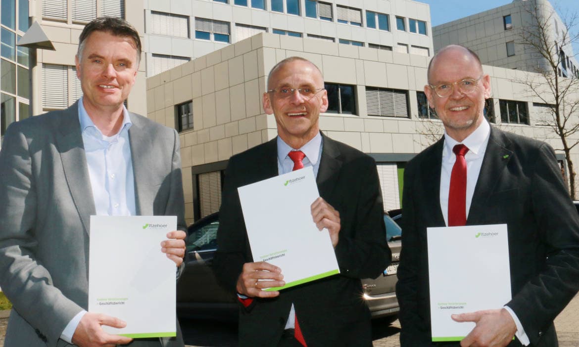 Drei Männer präsentieren Dokumente vor Firmengebäude, nach Sturm.