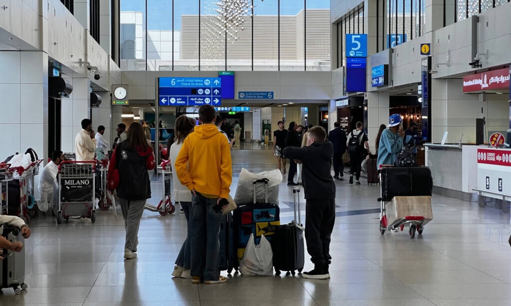 Passagiere am Flughafen mit Gepäck warten auf ihren Flug.
