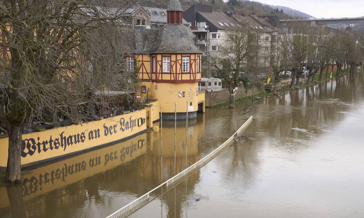 Überflutete Häuser am Flussufer während Hochwasser in Deutschland.