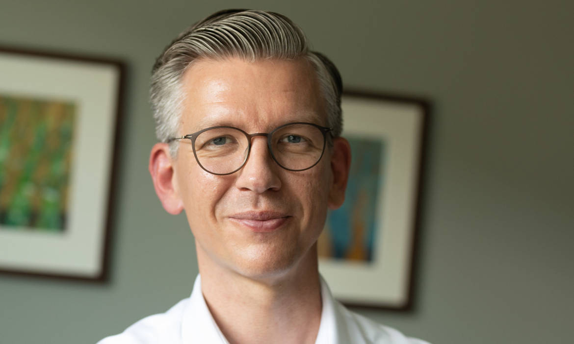 Mann mit Brille und weißem Hemd, professionelle Beratung zum Bestandskauf.