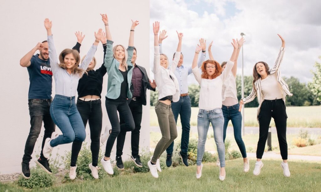 Menschen jubeln und feiern im Freien bei einer Gruppenaktivität.