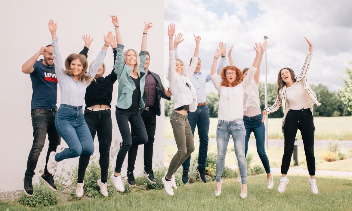 Menschen jubeln und feiern im Freien bei einer Gruppenaktivität.