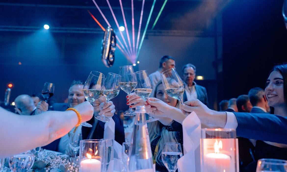Feierliche Menschen beim Anstoßen mit Sekt bei Gala-Event.