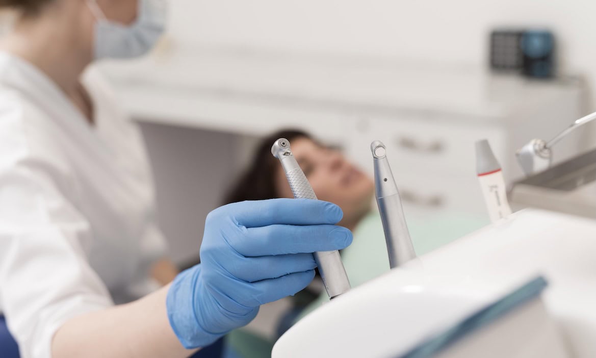 Zahnarzt behandelt Patient mit Dentalinstrumenten im Behandlungsraum.