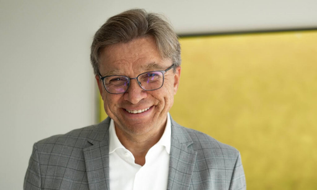 Geschäftsmann lächelt, symbolisiert Partnerschaft zwischen Germanbroker.net und Charta.