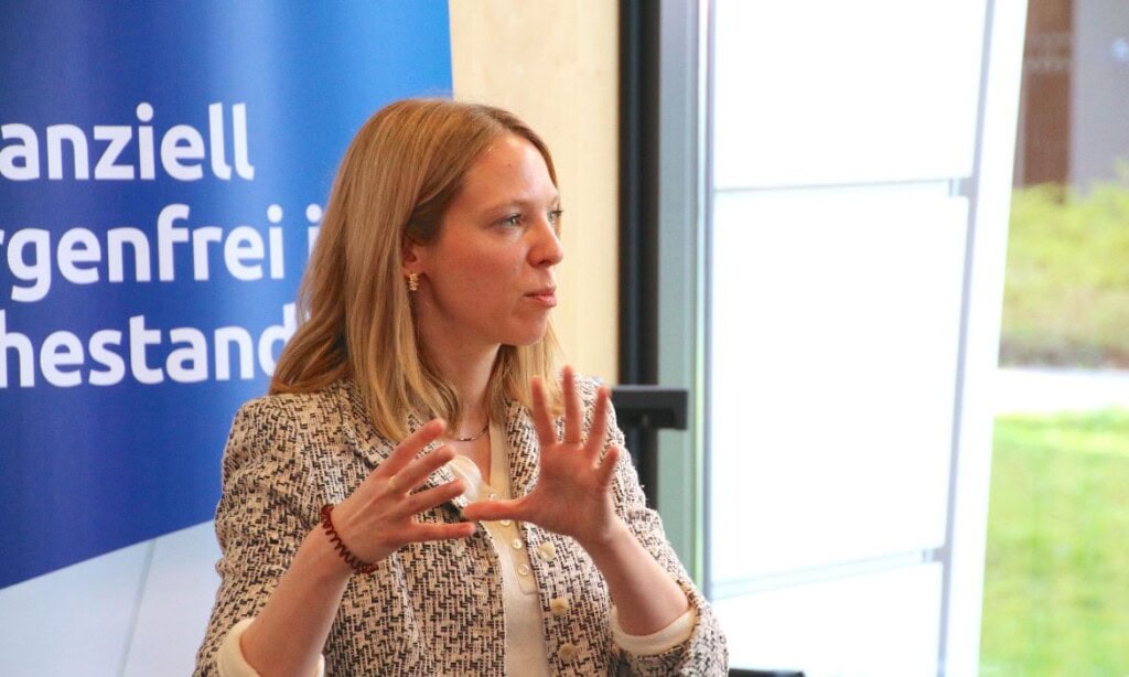 Frau spricht bei Finanzveranstaltung, erklärt wichtige Themen.