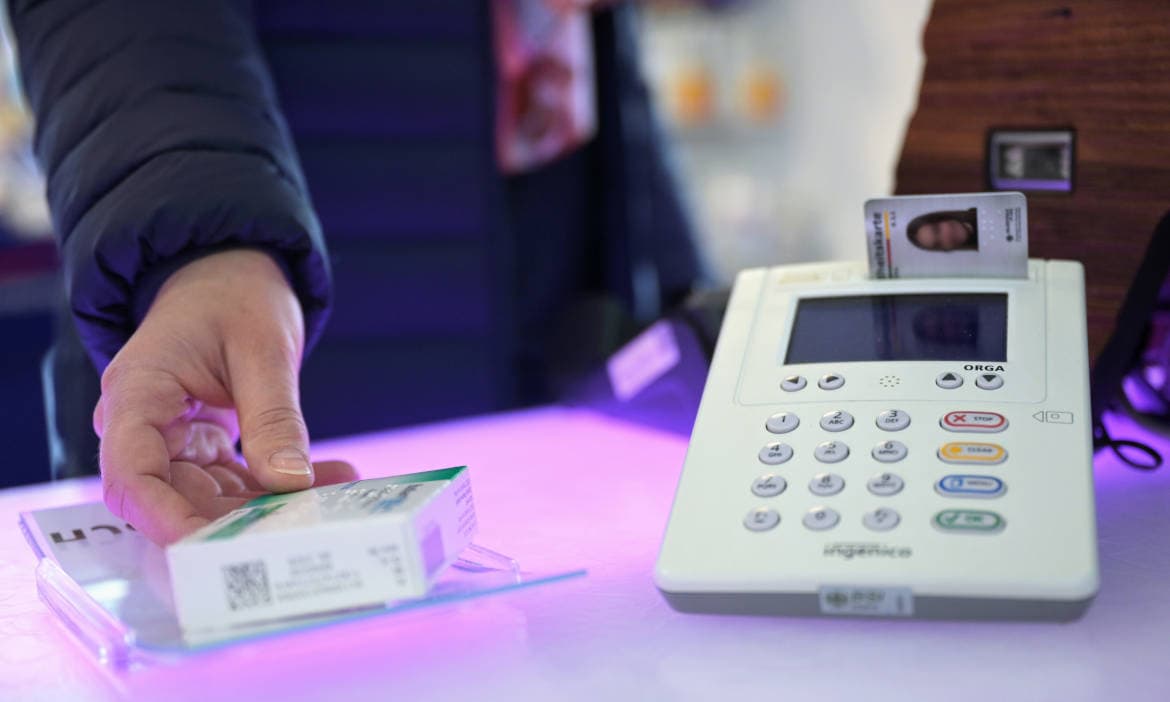 Person bezahlt an der Kasse mit Kreditkarte, Kassenterminal im Hintergrund.