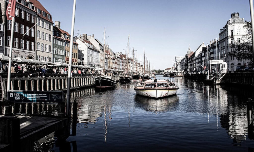 Blick auf einen Hafen mit Booten und historischen Gebäuden in einer europäischen Stadt.