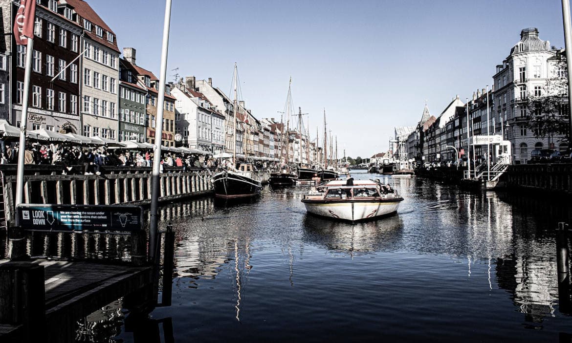 Blick auf einen Hafen mit Booten und historischen Gebäuden in einer europäischen Stadt.