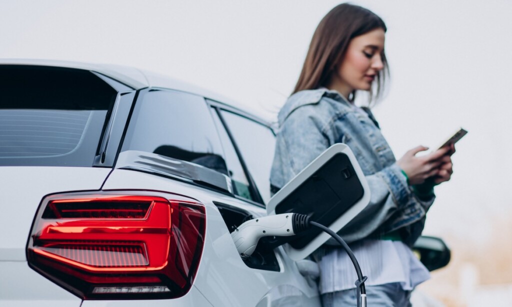 Eine Frau lädt ihr Elektroauto: Die hohen Spritpreise machen das E-Auto attratkiver.