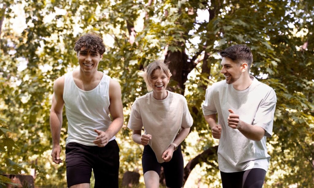 Drei junge Menschen beim Joggen im Park.