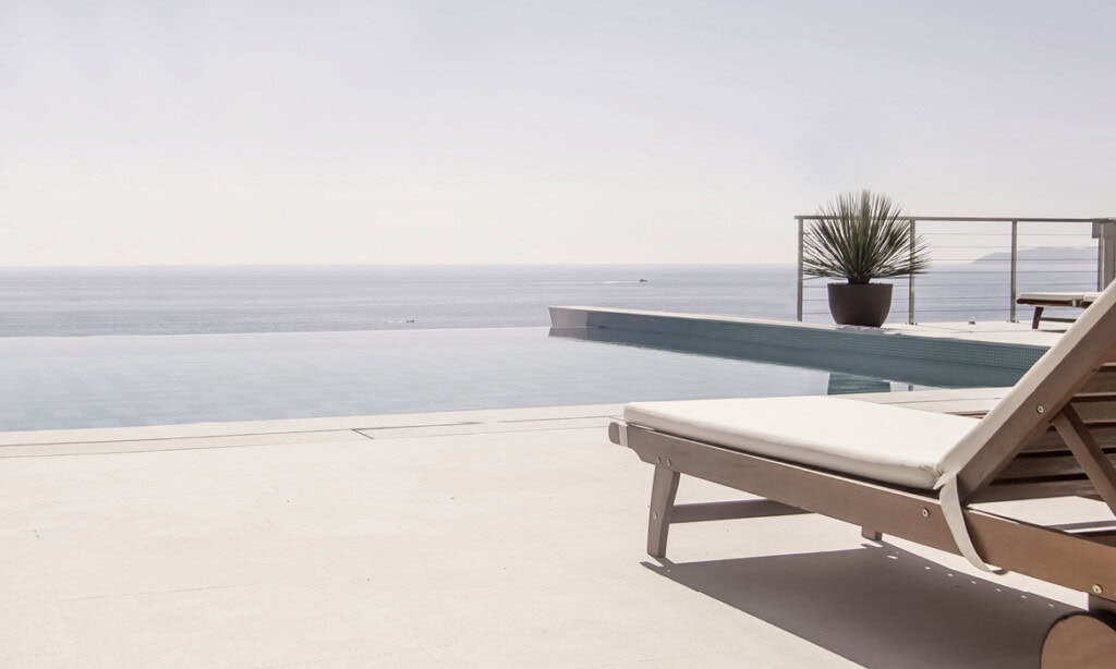Luxuriöser Pool mit Meerblick und Sonnenliege, ideal für Erholung.