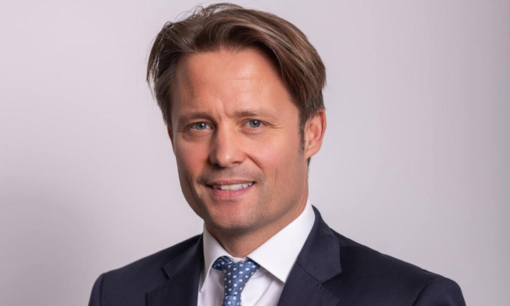 Mann in Anzug mit blauer Krawatte, professionell und vertrauenswürdig.