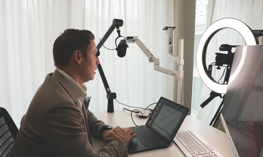 Mann bei Videoaufnahme mit Ringlicht und Kamera.