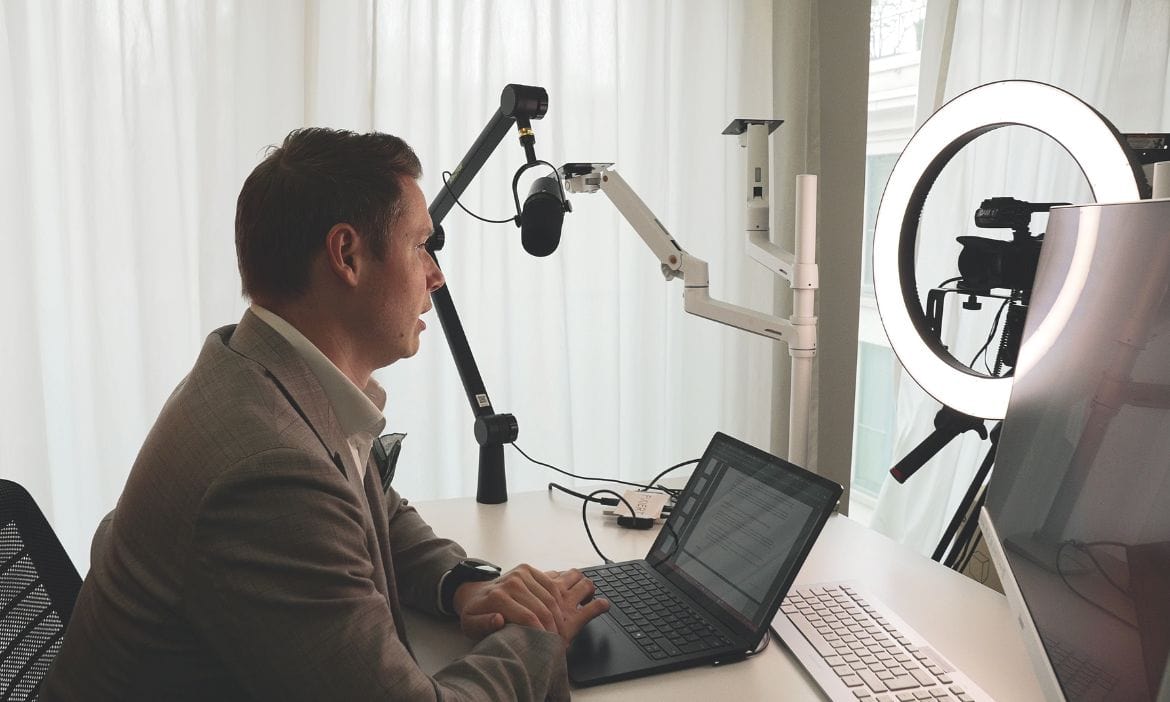 Mann bei Videoaufnahme mit Ringlicht und Kamera.