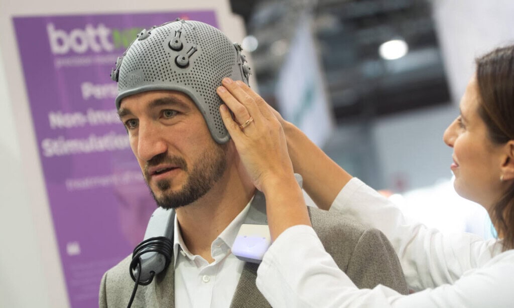 Hightech-Helm gegen Alzheimer, gebaut vom Schweizer Startup-Unternehmen Bottneuro, hier auf einer Messe in Düsseldorf: Viele neu gegründete Unternehmen auch in Deutschland kommen aus der Tech-Branche